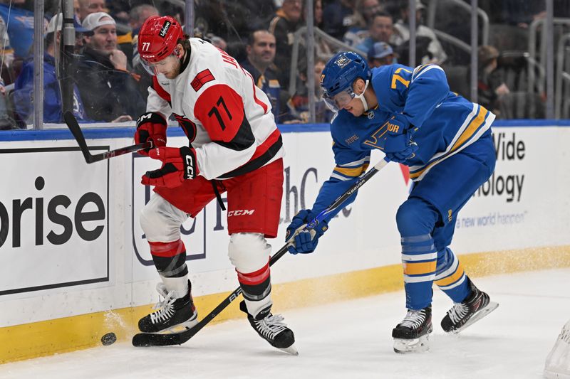 Jan 13, 2026; St. Louis, Missouri, USA; Carolina Hurricanes center Mark Jankowski (77) and St. Louis Blues center Nick Bjugstad (77) battle for the puck in the first period at Enterprise Center. Mandatory Credit: Joe Puetz-Imagn Images