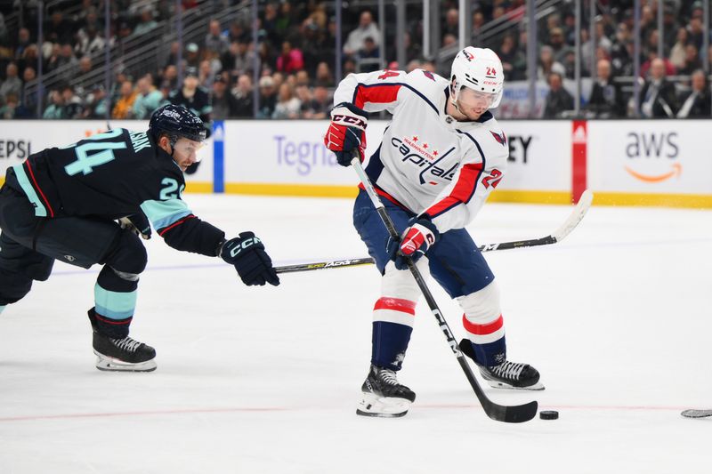 Mar 14, 2024; Seattle, Washington, USA; Washington Capitals center Connor McMichael (24) plays the puck while defended by Seattle Kraken defenseman Jamie Oleksiak (24) during the third period at Climate Pledge Arena. Mandatory Credit: Steven Bisig-USA TODAY Sports