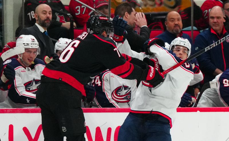 Apr 7, 2024; Raleigh, North Carolina, USA;  Carolina Hurricanes defenseman Brady Skjei (76) checks Columbus Blue Jackets left wing Mikael Pyyhtia (82) during the second period at PNC Arena. Mandatory Credit: James Guillory-USA TODAY Sports