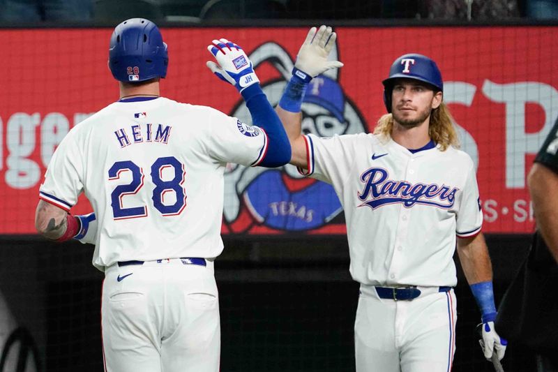 Aug 31, 2024; Arlington, Texas, USA; Texas Rangers catcher Jonah Heim (28) slaps the hand of right fielder Travis Jankowski (16) after hitting a two-run home run during the second inning against the Oakland Athletics at Globe Life Field. Mandatory Credit: Raymond Carlin III-USA TODAY Sports