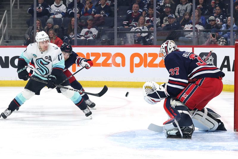 Jan 16, 2025; Winnipeg, Manitoba, CAN; Seattle Kraken center Jaden Schwartz (17) shoots on Winnipeg Jets goaltender Connor Hellebuyck (37) in the first period at Canada Life Centre. Mandatory Credit: James Carey Lauder-Imagn Images