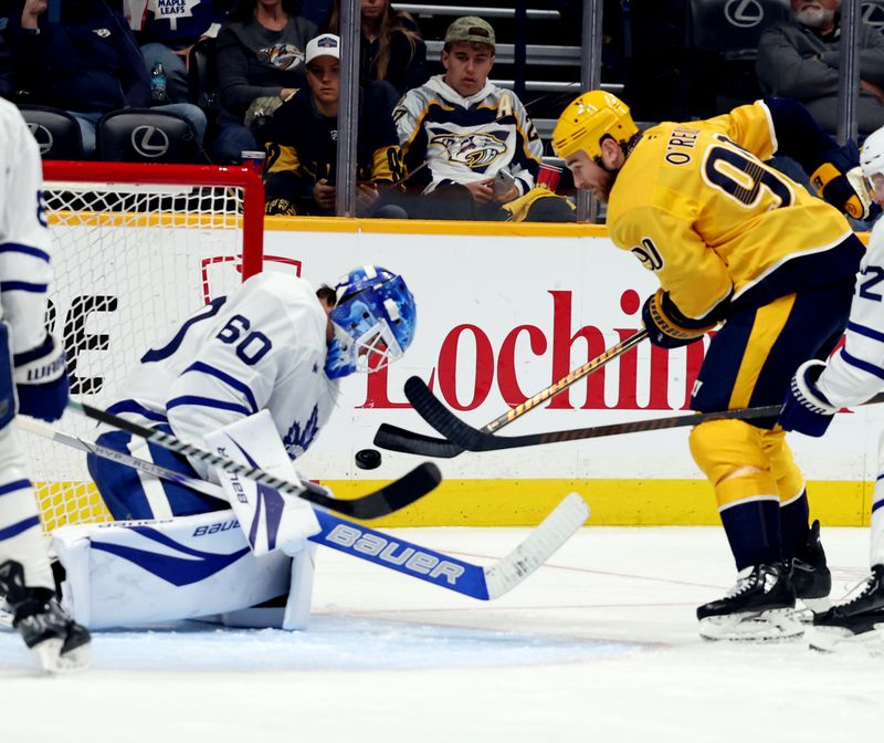 Mar 22, 2025; Nashville, Tennessee, USA; Toronto Maple Leafs goalie Joseph Woll (60) stops a shot by Nashville Predators center Ryan O'Reilly (90) during the third period of the game at Bridgestone Arena. Mandatory Credit: Alan Poizner-Imagn Images