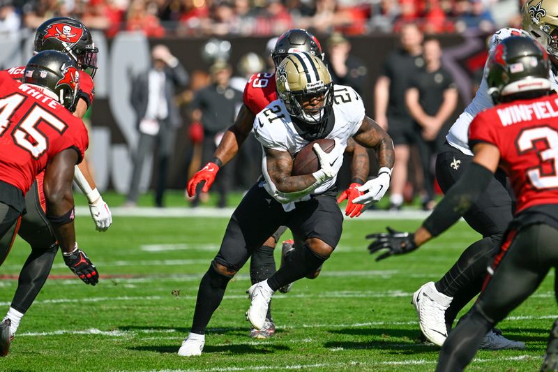 New Orleans Saints running back Jamaal Williams (21) caries past Tampa Bay Buccaneers safety Christian Izien (29) in the first half of an NFL football game in Tampa, Fla., Sunday, Dec. 31, 2023. (AP Photo/Jason Behnken)