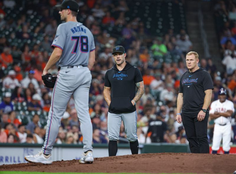 Jul 10, 2024; Houston, Texas, USA; Miami Marlins manager Skip Schumaker (45) watches with medical staff as starting pitcher Bryan Hoeing (78) throws practice pitches during the third inning against the Houston Astros at Minute Maid Park. Mandatory Credit: Troy Taormina-USA TODAY Sports