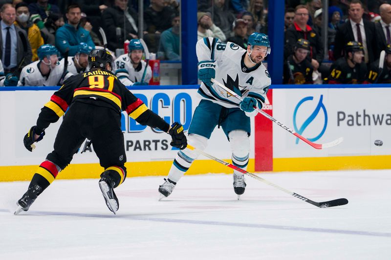 Dec 23, 2023; Vancouver, British Columbia, CAN; San Jose Sharks forward Tomas Hertl (48) passes around Vancouver Canucks defenseman Nikita Zadorov (91) in the second period at Rogers Arena. Mandatory Credit: Bob Frid-USA TODAY Sports