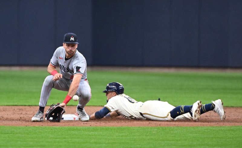 Apr 3, 2024; Milwaukee, Wisconsin, USA; Milwaukee Brewers center fielder Sal Frelick (10) slides safely into second base against Minnesota Twins second baseman Edouard Julien (47) in the second inning at American Family Field. Mandatory Credit: Michael McLoone-USA TODAY Sports