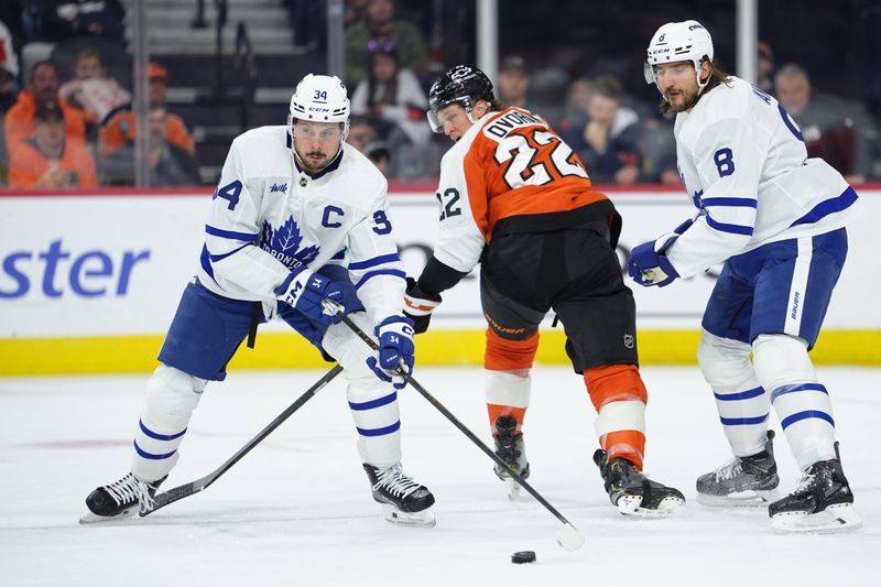 Nov 1, 2025; Philadelphia, Pennsylvania, USA; Toronto Maple Leafs center Auston Matthews (34) checks the puck from Philadelphia Flyers center Christian Dvorak (22) in the second period at Xfinity Mobile Arena. Mandatory Credit: Kyle Ross-Imagn Images
