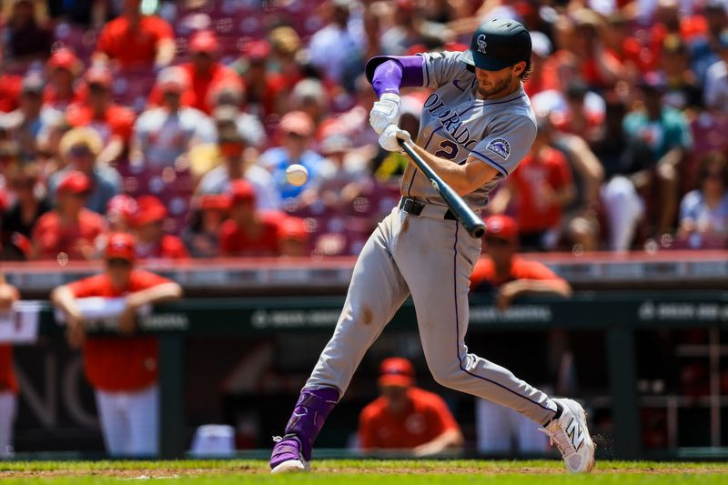 Jul 13, 2025; Cincinnati, Ohio, USA; Colorado Rockies third baseman Ryan McMahon (24) hits a single in the sixth inning against the Cincinnati Reds at Great American Ball Park. Mandatory Credit: Katie Stratman-Imagn Images
