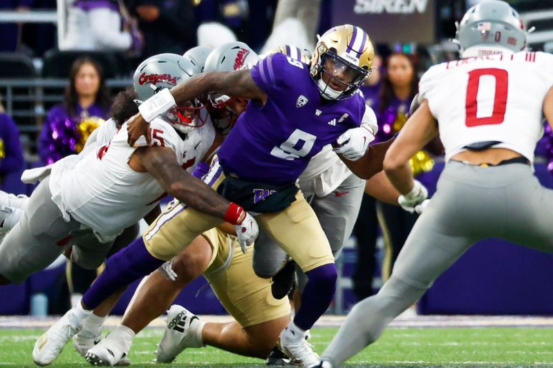 Nov 25, 2023; Seattle, Washington, USA; Washington Huskies quarterback Michael Penix Jr. (9) passes while under pressure from Washington State Cougars defensive lineman Nusi Malani (15) during the fourth quarter at Alaska Airlines Field at Husky Stadium. Mandatory Credit: Joe Nicholson-USA TODAY Sports