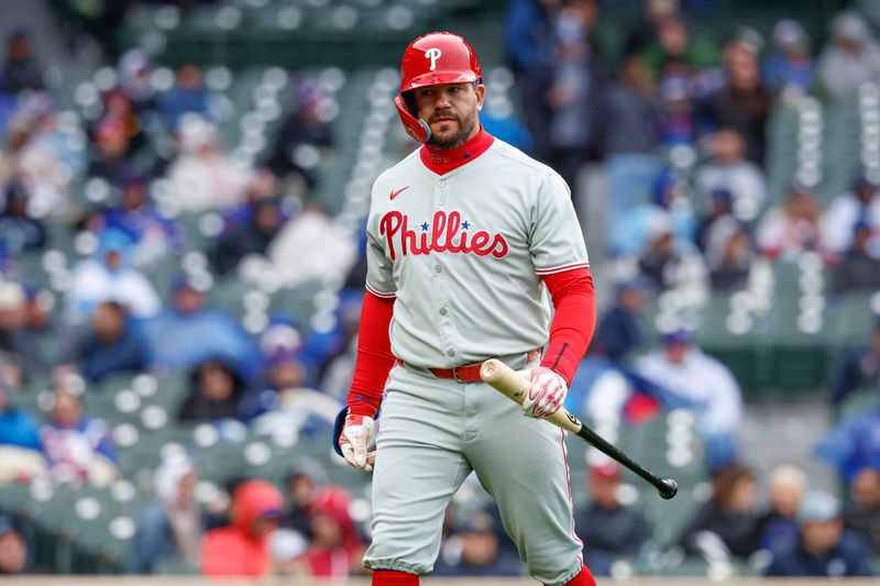 Apr 25, 2025; Chicago, Illinois, USA; Philadelphia Phillies designated hitter Kyle Schwarber (12) walks back to the dugout after striking out against the Chicago Cubs during the eighth inning at Wrigley Field. Mandatory Credit: Kamil Krzaczynski-Imagn Images