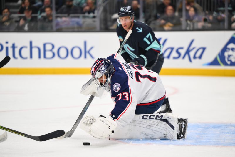 Nov 11, 2025; Seattle, Washington, USA; Columbus Blue Jackets goaltender Jet Greaves (73) traps the puck during the second period against the Seattle Kraken at Climate Pledge Arena. Mandatory Credit: Steven Bisig-Imagn Images