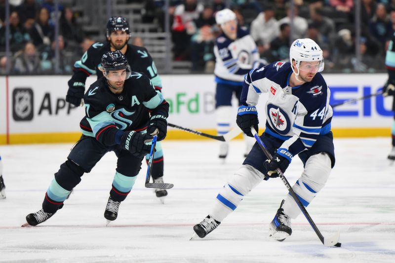 Mar 8, 2024; Seattle, Washington, USA; Winnipeg Jets defenseman Josh Morrissey (44) plays the puck while defended by Seattle Kraken right wing Jordan Eberle (7) during the second period at Climate Pledge Arena. Mandatory Credit: Steven Bisig-USA TODAY Sports