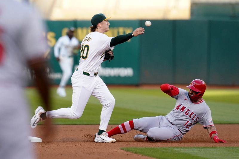 Jul 19, 2024; Oakland, California, USA; Oakland Athletics second baseman Zack Gelof (20) turns a double play over the top of Los Angeles Angels center fielder Kevin Pillar (12) in the fourth inning at Oakland-Alameda County Coliseum. Mandatory Credit: Cary Edmondson-USA TODAY Sports