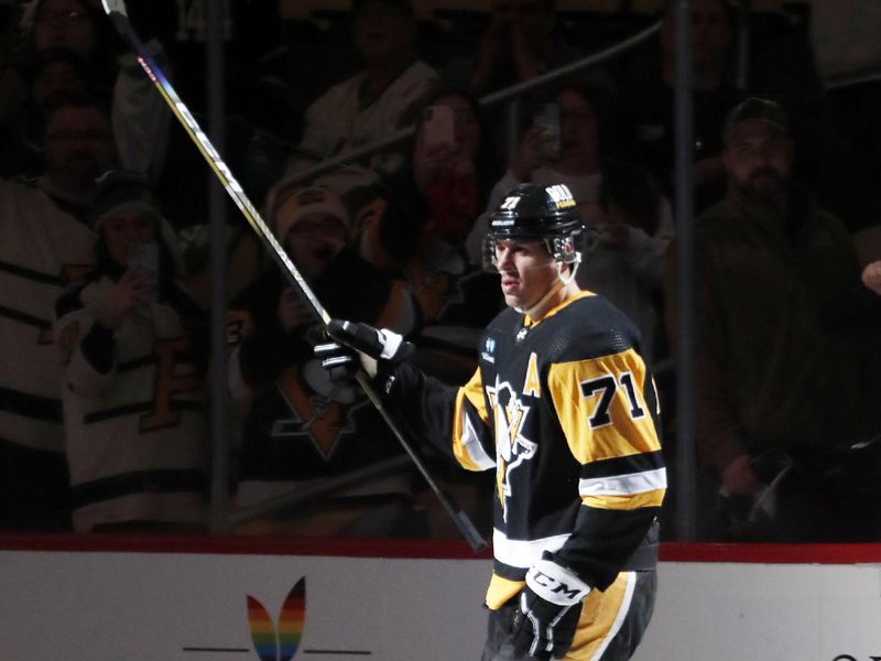 Dec 12, 2022; Pittsburgh, Pennsylvania, USA; Pittsburgh Penguins center Evgeni Malkin (71) raises his stick to salute the crowd after being named the first star of the game against the Dallas Stars at PPG Paints Arena. The Penguins won 2-1. Mandatory Credit: Charles LeClaire-USA TODAY Sports