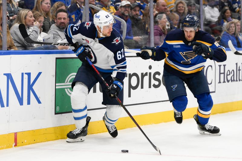 Oct 22, 2024; St. Louis, Missouri, USA; Winnipeg Jets right wing Nino Niederreiter (62) controls the puck from St. Louis Blues defenseman Philip Broberg (6) during the first period at Enterprise Center. Mandatory Credit: Jeff Le-Imagn Images 