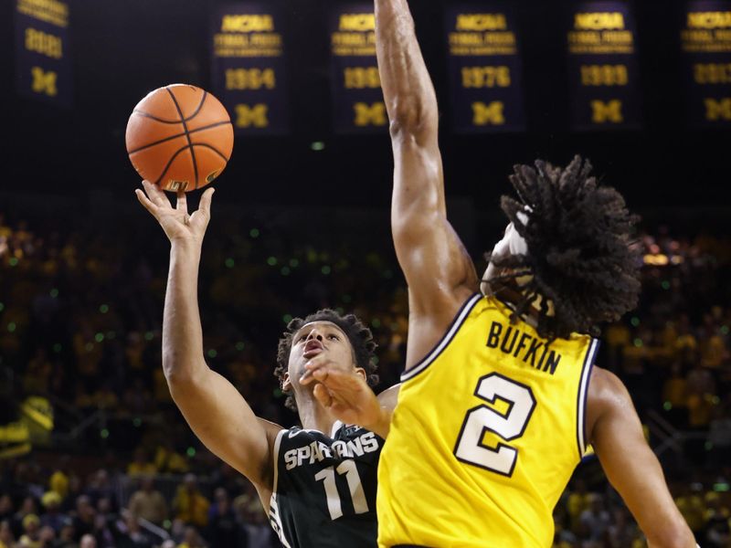 Feb 18, 2023; Ann Arbor, Michigan, USA;  Michigan State Spartans guard A.J. Hoggard (11) shoots the ball against Michigan Wolverines guard Kobe Bufkin (2) in the second half at Crisler Center. Mandatory Credit: Rick Osentoski-USA TODAY Sports