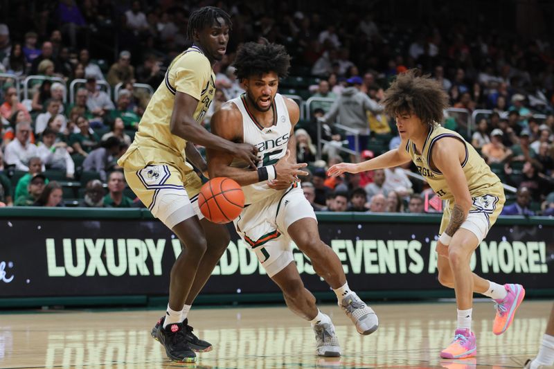 Feb 24, 2024; Coral Gables, Florida, USA; Miami Hurricanes forward Norchad Omier (15) loses the basketball while driving to the basket against Georgia Tech Yellow Jackets guard Naithan George (2) and forward Baye Ndongo (11) during the second half at Watsco Center. Mandatory Credit: Sam Navarro-USA TODAY Sports