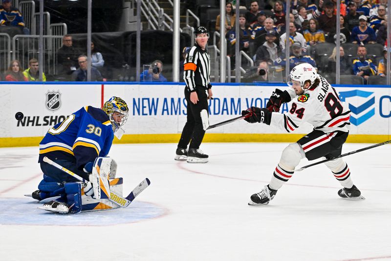 Apr 10, 2024; St. Louis, Missouri, USA;  Chicago Blackhawks left wing Landon Slaggert (84) shoots and scores his first career NHL goal against St. Louis Blues goaltender Joel Hofer (30) during the third period at Enterprise Center. Mandatory Credit: Jeff Curry-USA TODAY Sports