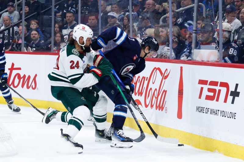 Oct 13, 2024; Winnipeg, Manitoba, CAN;  Minnesota Wild defenseman Zach Bogosian (24) battles Winnipeg Jets forward Vladislav Namestnikov (7) for the puck during the second period at Canada Life Centre. Mandatory Credit: Terrence Lee-Imagn Images