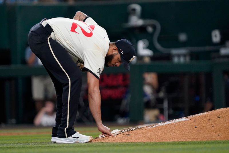 Jul 19, 2024; Arlington, Texas, USA; Texas Rangers pitcher Jonathan Hernández (72) writes in the dirty on the mound with his pinkie prior to pitching during the sixth inning against the Baltimore Orioles at Globe Life Field. Mandatory Credit: Raymond Carlin III-USA TODAY Sports