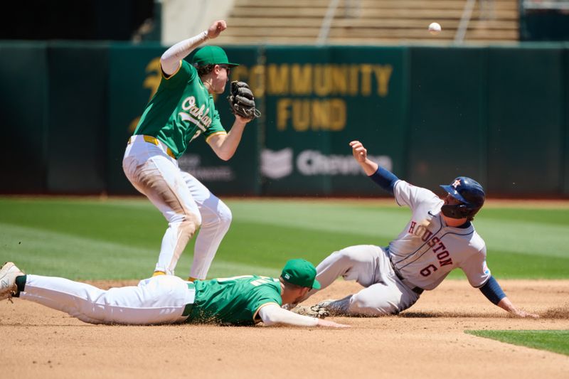 May 26, 2024; Oakland, California, USA; Oakland Athletics infielder Max Schuemann (12) commits a throwing error to infielder Zack Gelof (20) as Houston Astros outfielder Jake Meyers (6) slides into second base during the fourth inning at Oakland-Alameda County Coliseum. Mandatory Credit: Robert Edwards-USA TODAY Sports