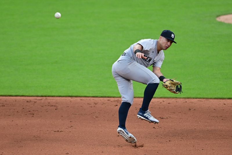Apr 21, 2025; Cleveland, Ohio, USA; New York Yankees shortstop Anthony Volpe (11) misplays the ball during the fifth inning against the Cleveland Guardians at Progressive Field. Mandatory Credit: David Dermer-Imagn Images