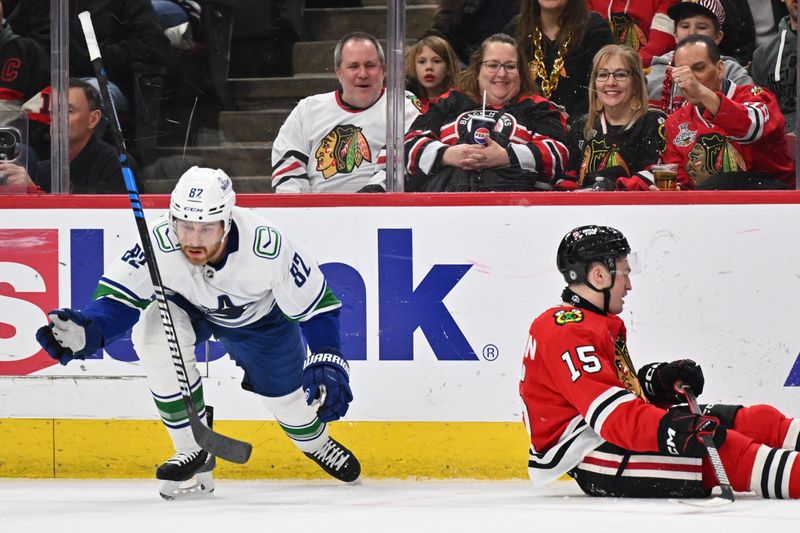 Feb 13, 2024; Chicago, Illinois, USA;  Vancouver Canucks defenseman Ian Cole (82) attempts to grab his stick after tripping Chicago Blackhawks forward Joey Anderson (15) in the first period at United Center. Mandatory Credit: Jamie Sabau-USA TODAY Sports