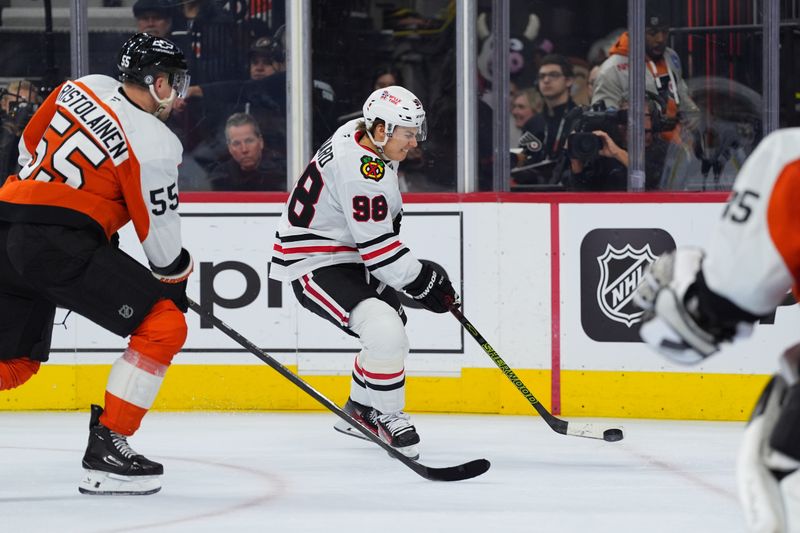 Nov 23, 2024; Philadelphia, Pennsylvania, USA; Chicago Blackhawks center Connor Bedard (98) shoots the puck against Philadelphia Flyers defenseman Rasmus Ristolainen (55) in the second period at Wells Fargo Center. Mandatory Credit: Kyle Ross-Imagn Images