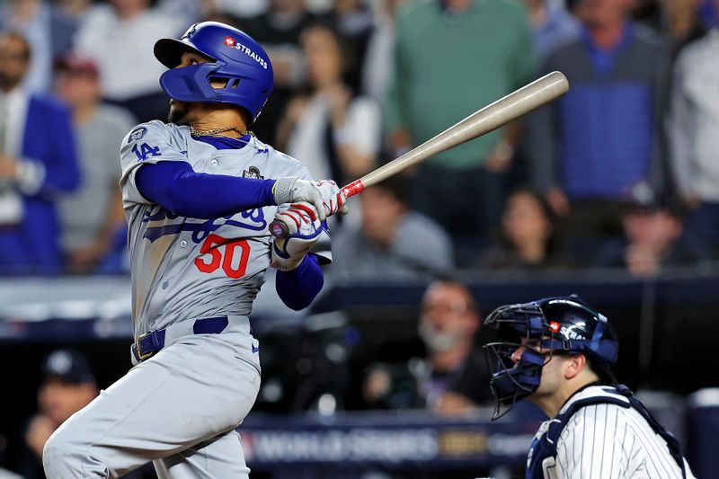 Oct 30, 2024; New York, New York, USA; Los Angeles Dodgers shortstop Mookie Betts (50) hits a sacrifice fly during the eighth inning against the New York Yankees in game four of the 2024 MLB World Series at Yankee Stadium. Mandatory Credit: Brad Penner-Imagn Images