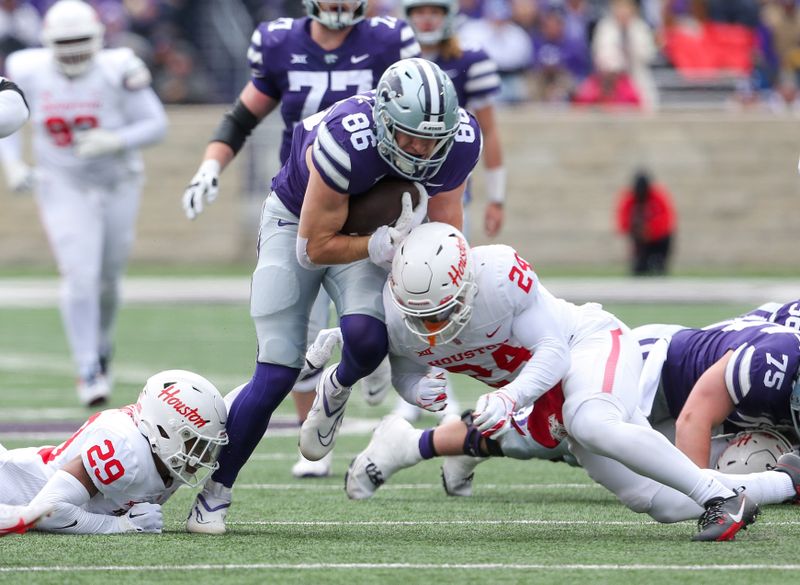 Oct 28, 2023; Manhattan, Kansas, USA; Kansas State Wildcats tight end Garrett Oakley (86) is tackled by Houston Cougars defensive back Adari Haulcy (24) and linebacker Treylin Payne (29) during the fourth quarter at Bill Snyder Family Football Stadium. Mandatory Credit: Scott Sewell-USA TODAY Sports