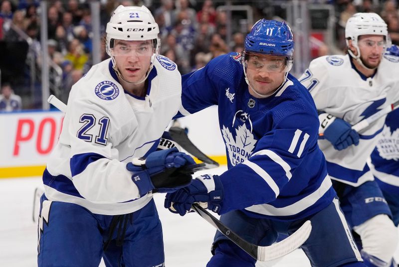 Nov 6, 2023; Toronto, Ontario, CAN; Tampa Bay Lightning forward Brayden Point (21) and Toronto Maple Leafs forward Max Domi (11) battle for position during the third period at Scotiabank Arena. Mandatory Credit: John E. Sokolowski-USA TODAY Sports