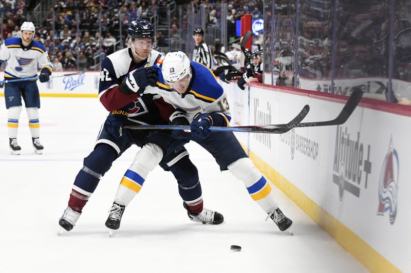 Jan 31, 2025; Denver, Colorado, USA; Colorado Avalanche defenseman Josh Manson (42) and St. Louis Blues right wing Alexey Toropchenko (13) battle for a puck along the boards during the third period at Ball Arena. Mandatory Credit: Christopher Hanewinckel-Imagn Images