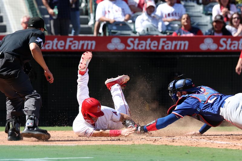 Sep 29, 2024; Anaheim, California, USA;  Texas Rangers catcher Jonah Heim (28) tags out Los Angeles Angels catcher Matt Thaiss (21) at home plate during the seventh inning at Angel Stadium. Mandatory Credit: Kiyoshi Mio-Imagn Images