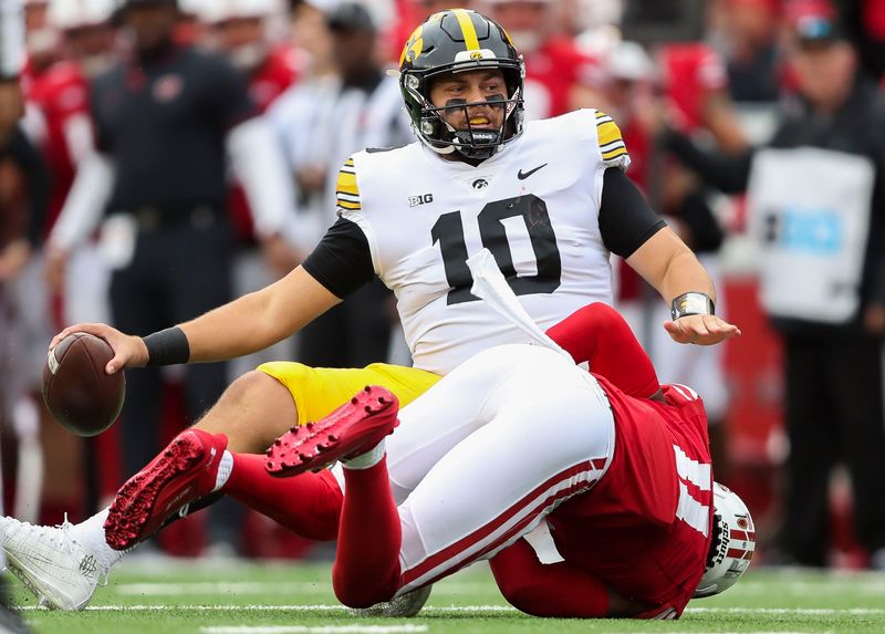 Oct 14, 2023; Madison, Wisconsin, USA; Wisconsin Badgers cornerback Alexander Smith (11) sacks Iowa Hawkeyes quarterback Deacon Hill (10) at Camp Randall Stadium. Mandatory Credit: Tork Mason-USA TODAY Sports