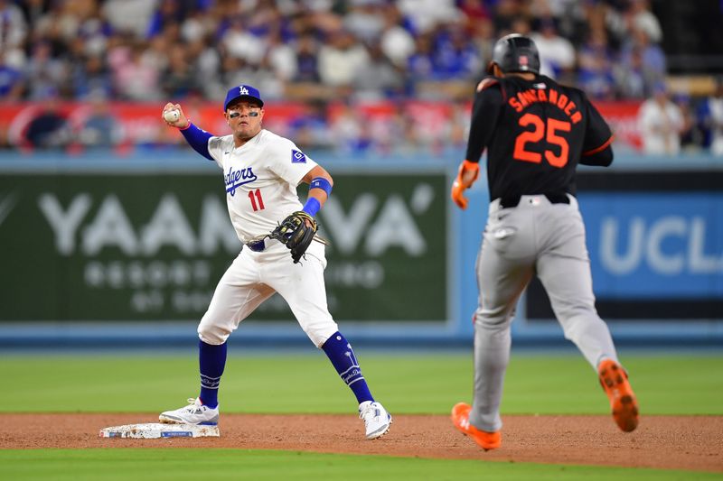 Aug 29, 2024; Los Angeles, California, USA; Baltimore Orioles right fielder Anthony Santander (25) is out at second as Los Angeles Dodgers shortstop Miguel Rojas (11) throws to first for the out against first baseman Ryan O'Hearn (32) during the fourth inning at Dodger Stadium. Mandatory Credit: Gary A. Vasquez-USA TODAY Sports