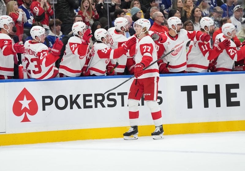 Apr 13, 2024; Toronto, Ontario, CAN; Detroit Red Wings defenseman Simon Edvinsson (77) celebrates at the bench after scoring a goal against the Toronto Maple Leafs during the first period at Scotiabank Arena. Mandatory Credit: Nick Turchiaro-USA TODAY Sports