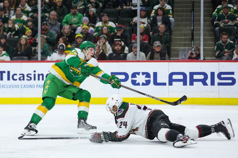 Jan 13, 2024; Saint Paul, Minnesota, USA; Minnesota Wild left wing Matt Boldy (12) shoots as Arizona Coyotes defenseman Matt Dumba (24) defends during the third period at Xcel Energy Center. Mandatory Credit: Matt Krohn-USA TODAY Sports