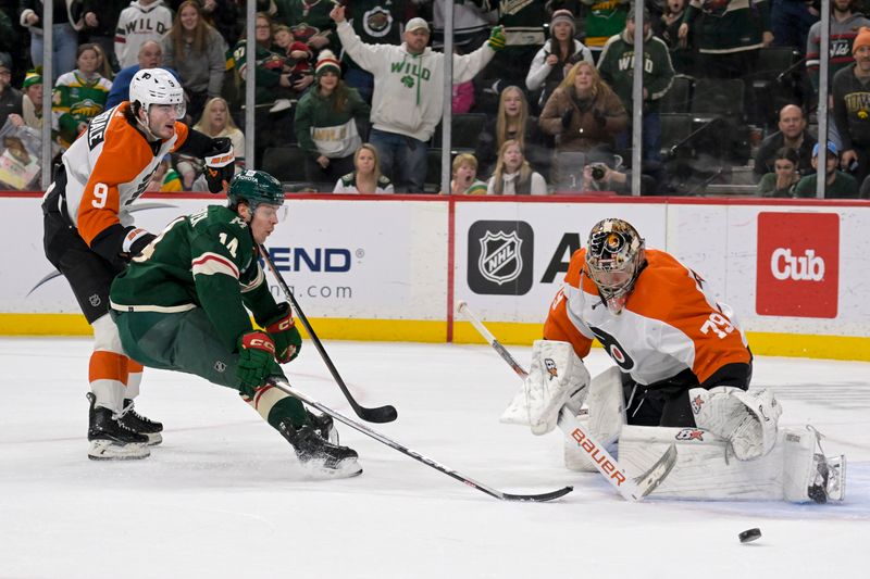 Jan 12, 2024; Saint Paul, Minnesota, USA; Philadelphia Flyers defenseman Jamie Drysdale (9) breaks up a scoring chance of Minnesota Wild forward Joel Eriksson Ek (14) on goalie Carter Hart (79) during overtime at Xcel Energy Center. Mandatory Credit: Nick Wosika-USA TODAY Sports