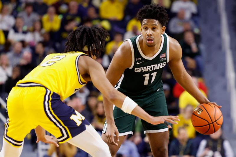 Feb 18, 2023; Ann Arbor, Michigan, USA;  Michigan State Spartans guard A.J. Hoggard (11) dribbles the ball against Michigan Wolverines guard Kobe Bufkin (2) in the second half at Crisler Center. Mandatory Credit: Rick Osentoski-USA TODAY Sports