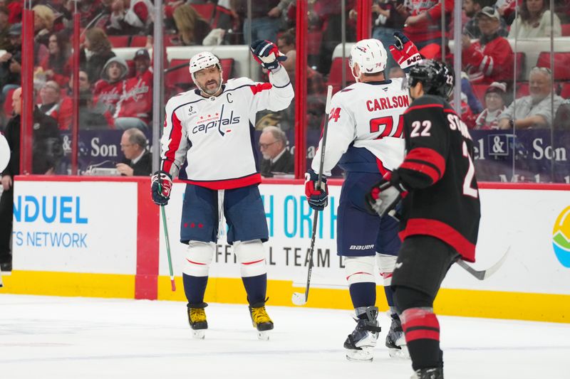 Nov 11, 2025; Raleigh, North Carolina, USA;  Washington Capitals left wing Alex Ovechkin (8) celebrates his empty net goal with defenseman John Carlson (74) against the Carolina Hurricanes during the third period at Lenovo Center. Mandatory Credit: James Guillory-Imagn Images