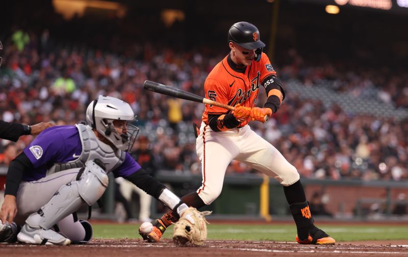 May 2, 2025; San Francisco, California, USA; Colorado Rockies catcher Jacob Stallings (25) is unable to control the ball on a wild pitch with San Francisco Giants second baseman Christian Koss (50) at bat during the second inning at Oracle Park. Mandatory Credit: Kelley L Cox-Imagn Images