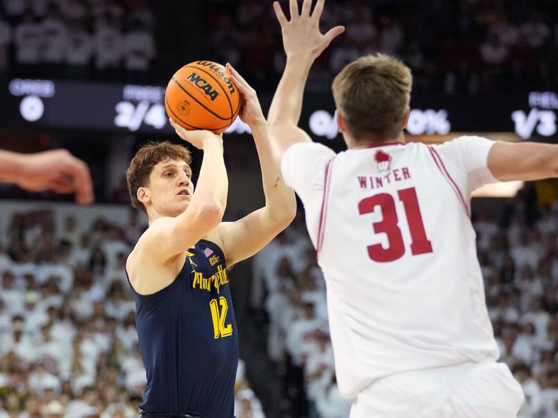 Dec 2, 2023; Madison, Wisconsin, USA;  Marquette Golden Eagles forward Ben Gold (12) scores against Wisconsin Badgers forward Nolan Winter (31) during the first half at the Kohl Center. Mandatory Credit: Kayla Wolf-USA TODAY Sports