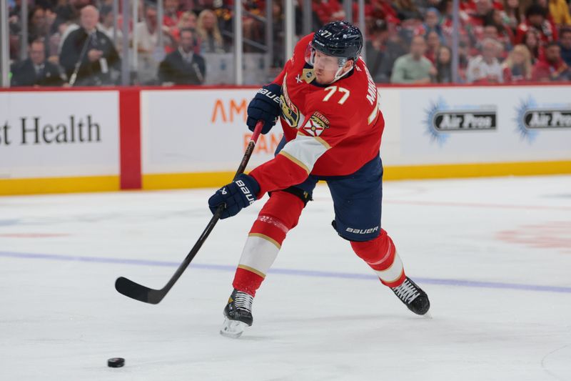 Nov 20, 2025; Sunrise, Florida, USA; Florida Panthers defenseman Niko Mikkola (77) shoots the puck against the New Jersey Devils during the second period at Amerant Bank Arena. Mandatory Credit: Sam Navarro-Imagn Images