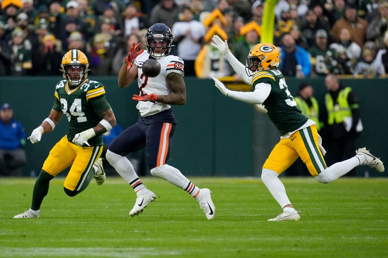 Chicago Bears wide receiver DJ Moore (2) catches a pass as Green Bay Packers safety Jonathan Owens (34) and cornerback Carrington Valentine defend during the first half of an NFL football game Sunday, Jan. 7, 2024, in Green Bay, Wis. (AP Photo/Morry Gash)