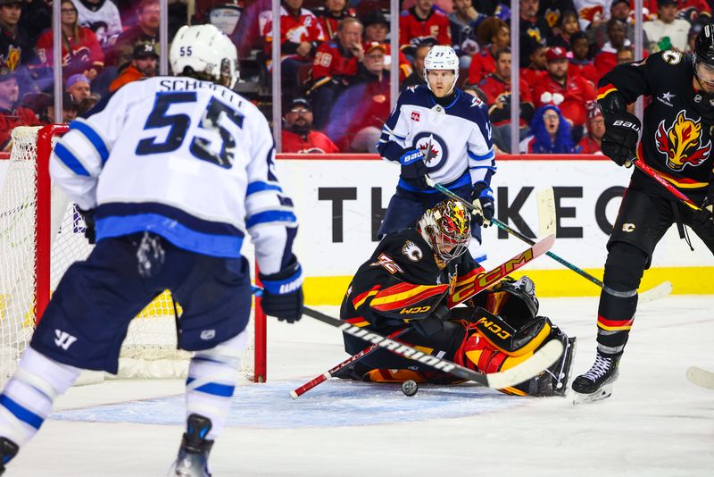 Oct 26, 2024; Calgary, Alberta, CAN; Calgary Flames goaltender Dustin Wolf (32) makes a save against the Winnipeg Jets during the third period at Scotiabank Saddledome. Mandatory Credit: Sergei Belski-Imagn Images