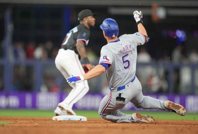 May 31, 2024; Miami, Florida, USA;  Texas Rangers shortstop Corey Seager (5) slides into second base with a double against the Miami Marlins in the ninth inning at loanDepot Park. Mandatory Credit: Jim Rassol-USA TODAY Sports