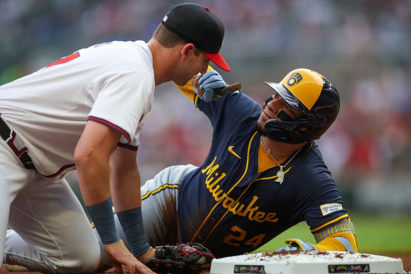 Aug 6, 2024; Atlanta, Georgia, USA; Milwaukee Brewers catcher William Contreras (24) looks at Atlanta Braves third baseman Austin Riley (27) after a triple in the first inning at Truist Park. Mandatory Credit: Brett Davis-USA TODAY Sports