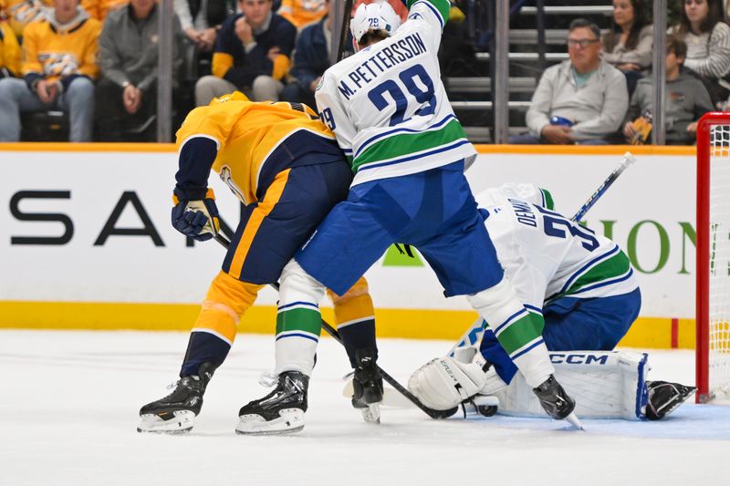 Vancouver Canucks goaltender Thatcher Demko (35) and defenseman Marcus Pettersson (29) blocks the shot of Nashville Predators left wing Michael Bunting (58) Oct 23, 2025; Nashville, Tennessee, USA;  during the first period at Bridgestone Arena. Mandatory Credit: Steve Roberts-Imagn Images