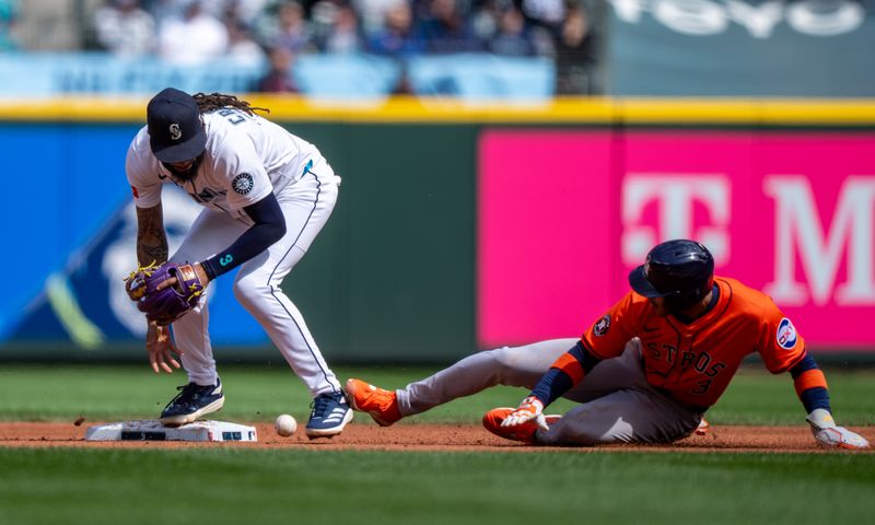 Apr 9, 2025; Seattle, Washington, USA;  Seattle Mariners shortstop J.P. Crawford (3) bobbles a ball as Houston Astros shortstop Jeremy Pena (3) slides safely into first base during the third inning at T-Mobile Park. Mandatory Credit: Stephen Brashear-Imagn Images