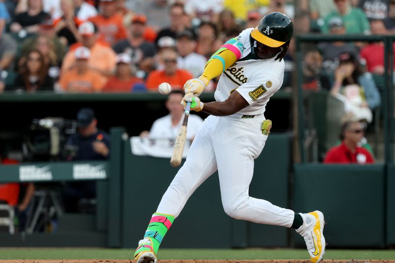 Jun 7, 2025; West Sacramento, California, USA; Athletics left fielder Lawrence Butler (4) hits a double against the Baltimore Orioles during the first inning at Sutter Health Park. Mandatory Credit: Dennis Lee-Imagn Images